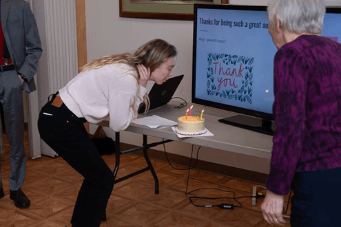 Lab member Kanji Rodriguez blowing out the candles for Darwin’s birthday cake. Humanist leader, Carol Auer (r), oversaw the ceremony. Photo credit: Carl Cox. 
