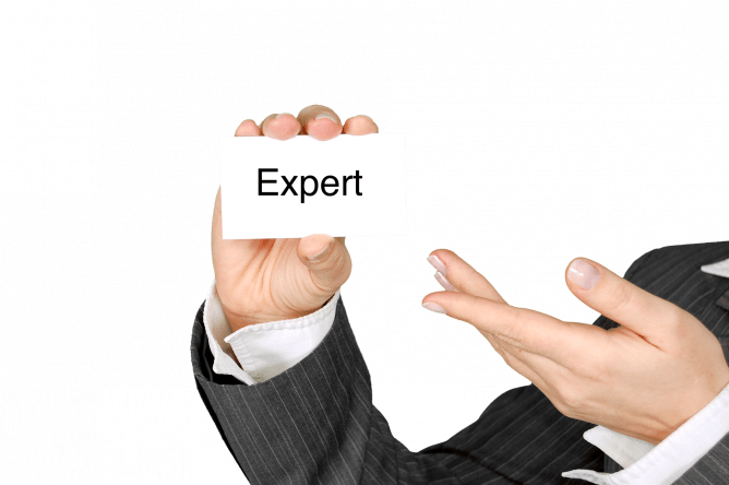 man holding index card that says "expert"