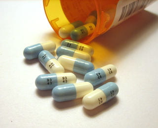 Prozac pills spilling out of a prescription bottle.